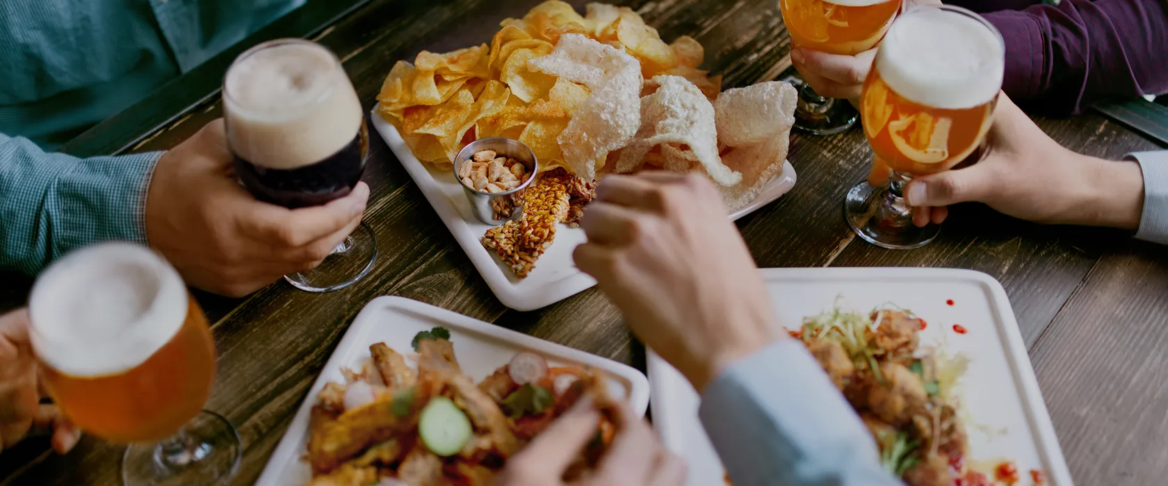 Groupe partageant tapas, chips et bières dans un cadre convivial et chaleureux